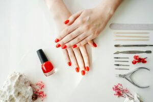 Manicured woman's nails with red nail polish.